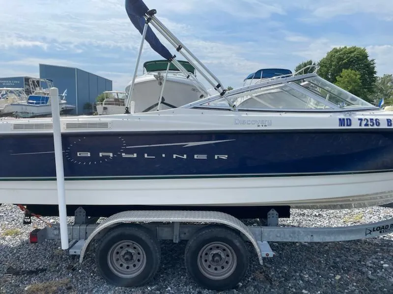 Slide: The Image of 2007 Bayliner Discovery 215 boat on a trailer in a marina. - 14