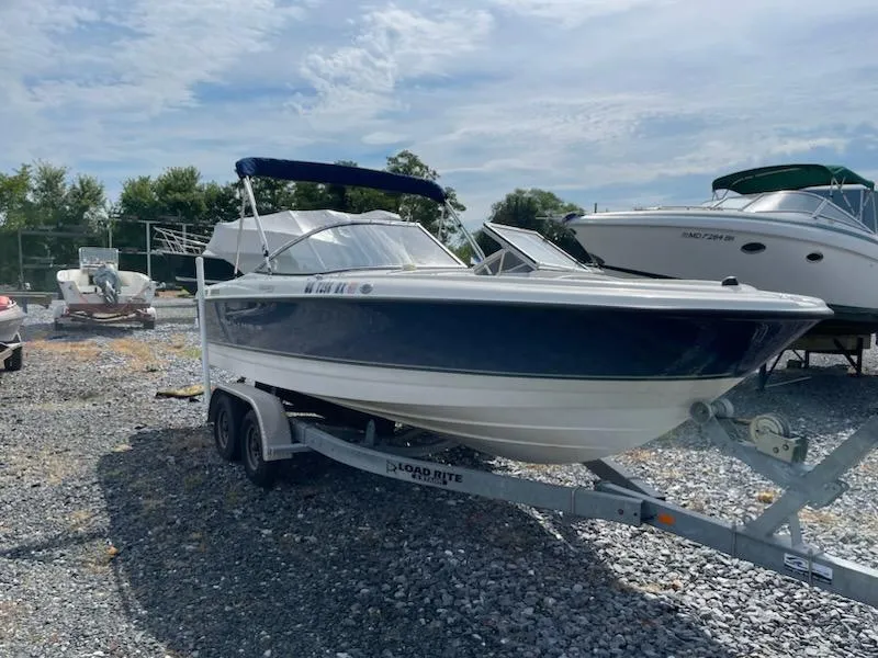 Slide: The Image of 2007 Bayliner Discovery 215 boat on a trailer in a gravel lot. - 15