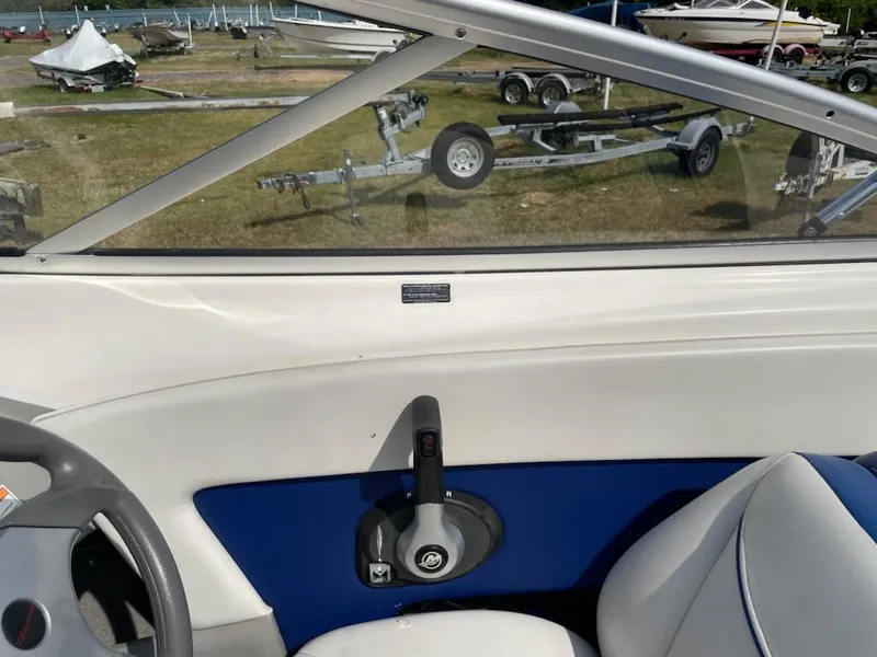 Slide: The Image of 2007 Bayliner Discovery 215 boat interior with control lever and seating. - 5