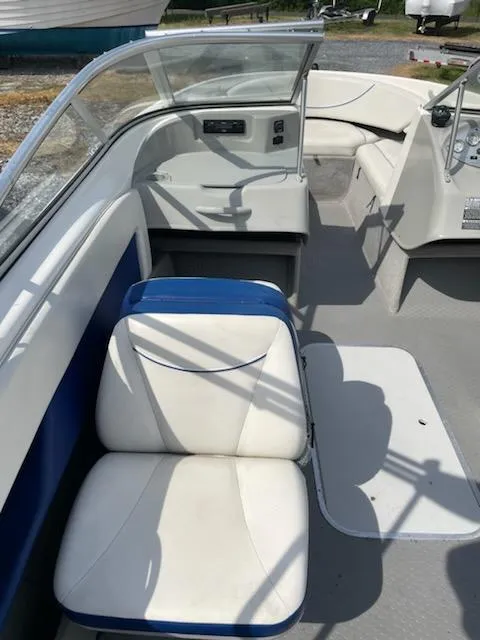 Slide: The Image of 2007 Bayliner Discovery 215 boat interior with white and blue seating. - 9
