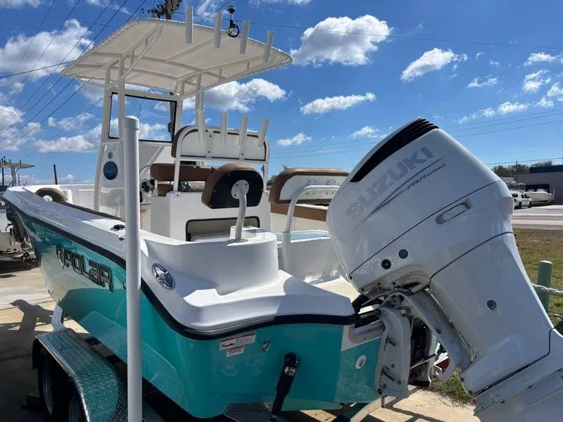 Slide: The Image of 2024 Polar 220 boat with Suzuki outboard motor, parked under a clear blue sky. - 2