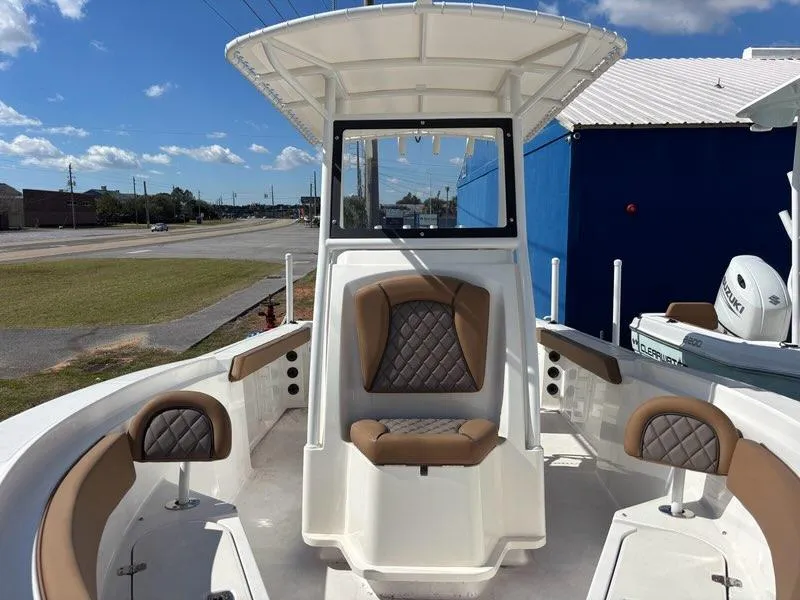 Slide: The Image of 2024 Polar 220 boat with cushioned seating and center console, parked outdoors. - 4