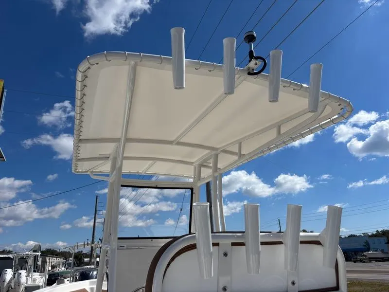 Slide: The Image of 2024 Polar 220 boat with T-top and rod holders under a clear blue sky. - 7