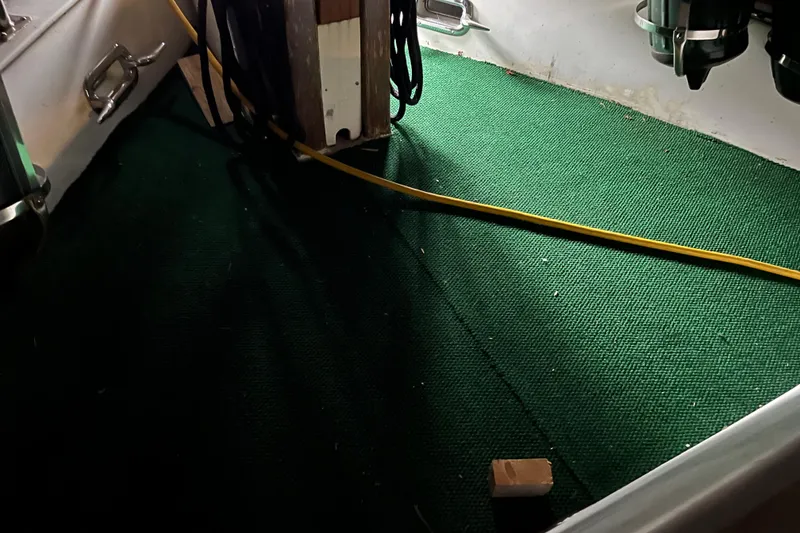 Slide: The Image of Interior of 1982 Monk 40 boat with green carpet and yellow cable. - 37