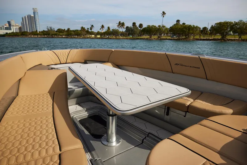 Slide: The Image of 2024 Midnight Express 37' Open boat with luxurious seating and table on the water. - 16