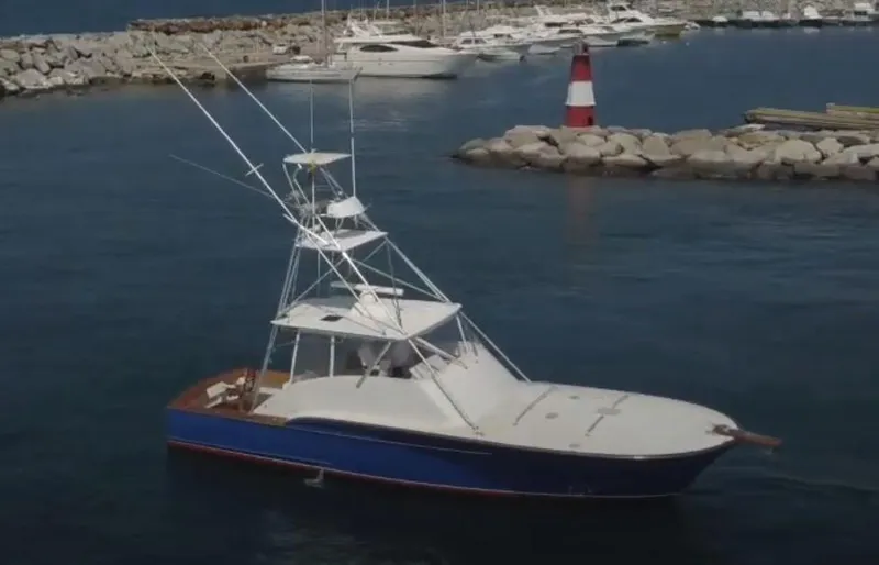 The Image of 2004 Buddy Davis 48 Express yacht in marina, with lighthouse and boats in background. - 0