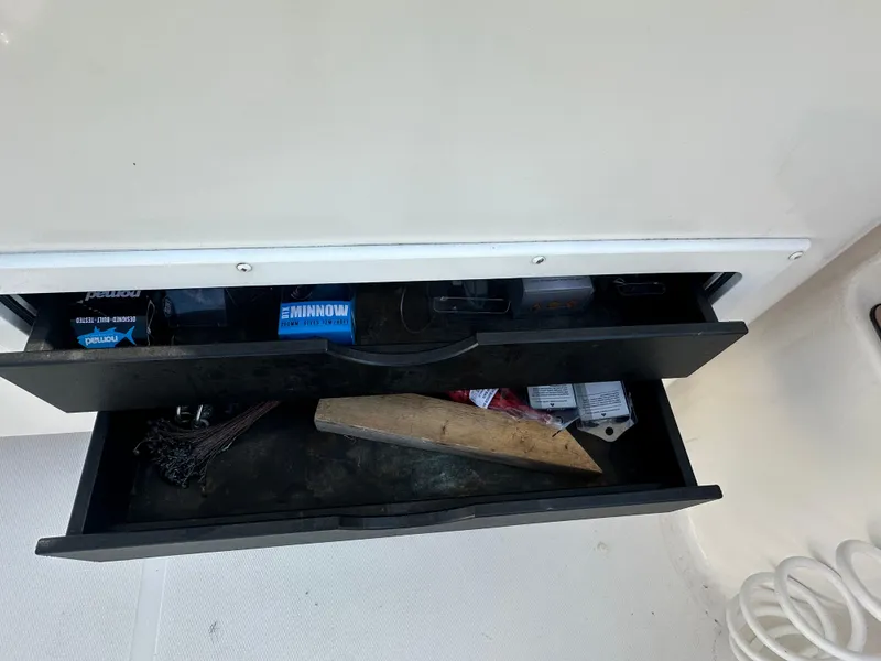Slide: The Image of Open storage drawers on a 2014 Albemarle 360 Express Fisherman boat, containing fishing gear. - 12