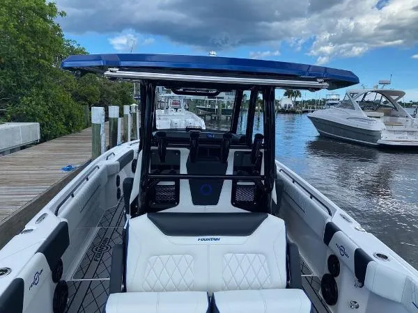 Slide: The Image of 2025 Fountain 32 NX boat interior at a marina with other boats docked. - 11