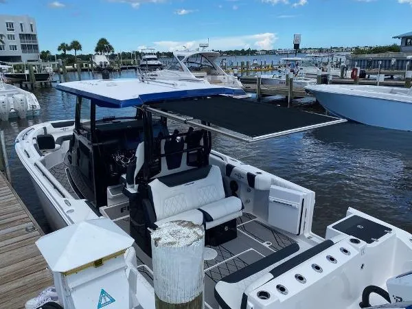 Slide: The Image of 2025 Fountain 32 NX boat interior with white and black seating at dock. - 22