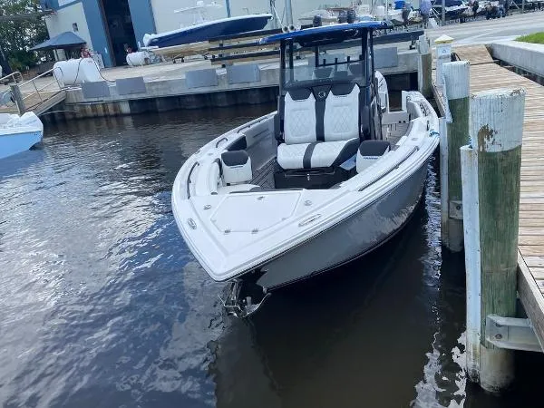 Slide: The Image of 2025 Fountain 32 NX boat docked at marina with extended sunshade. - 24