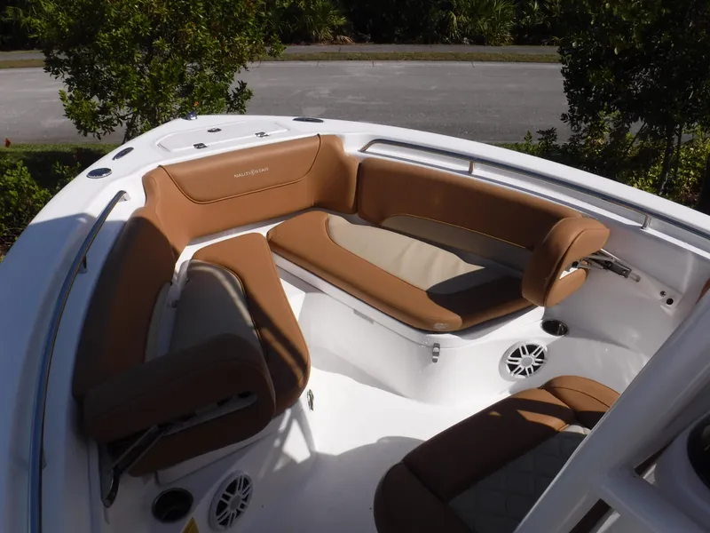 Slide: The Image of 2024 NauticStar 212 Legacy boat interior with tan seating and white deck. - 11