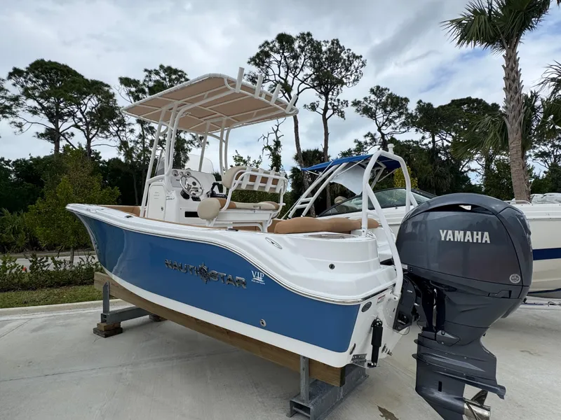 Slide: The Image of 2024 NauticStar 212 Legacy boat with Yamaha engine, parked outdoors. - 13