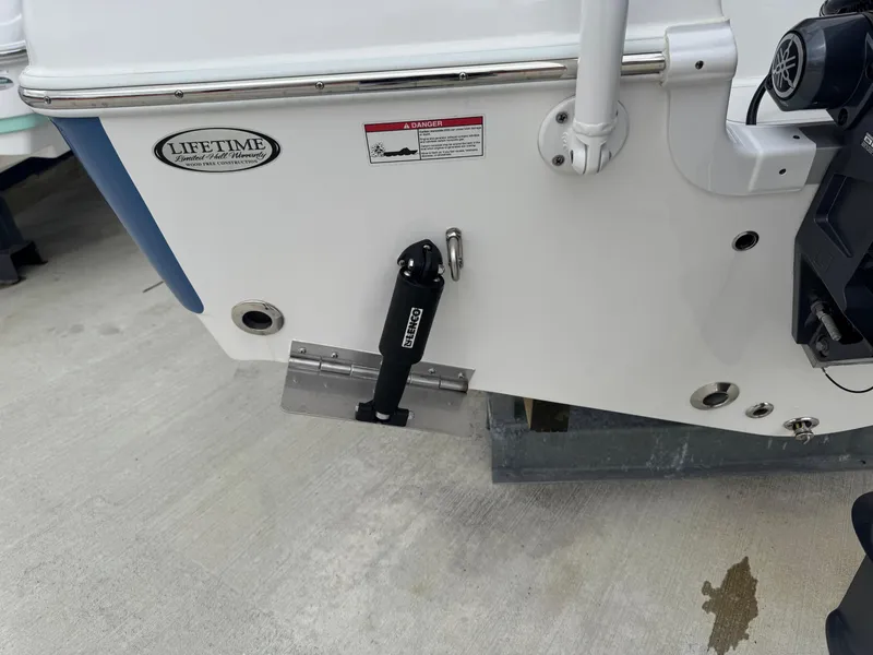 Slide: The Image of 2024 NauticStar 212 Legacy boat stern with trim tab and Lifetime warranty sticker. - 17