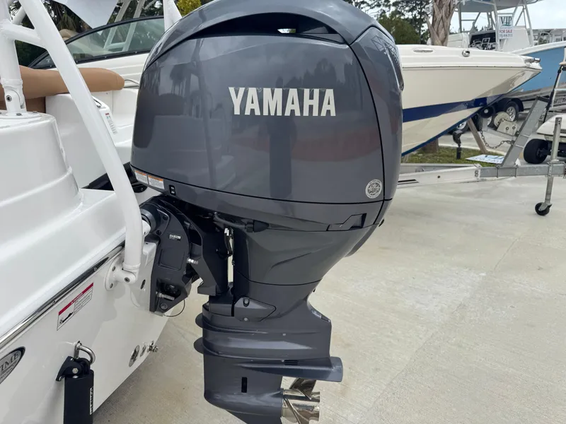 Slide: The Image of 2024 NauticStar 212 Legacy boat with Yamaha outboard motor, docked on concrete surface. - 18