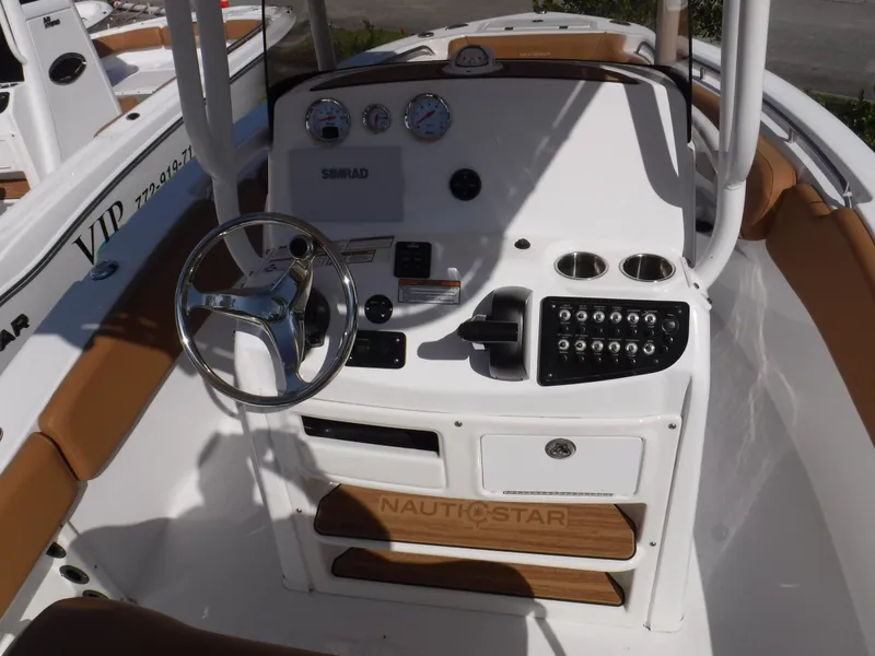 Slide: The Image of 2024 NauticStar 212 Legacy boat dashboard with steering wheel and control panel. - 4