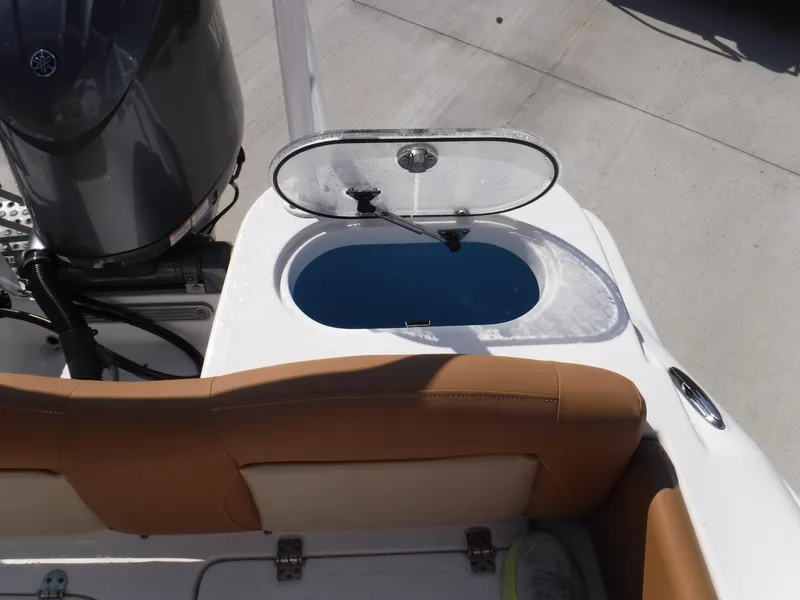 Slide: The Image of 2024 NauticStar 212 Legacy boat with open livewell and tan seating. - 8
