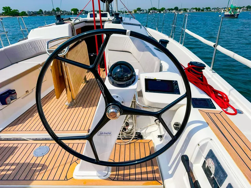 Slide: The Image of 2021 Dehler 42c sailboat cockpit with steering wheel, compass, and navigation equipment. - 11