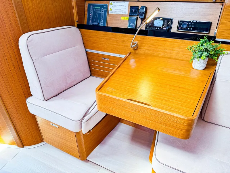 Slide: The Image of Interior of 2021 Dehler 42c yacht with wooden table, cushioned seats, and navigation equipment. - 26