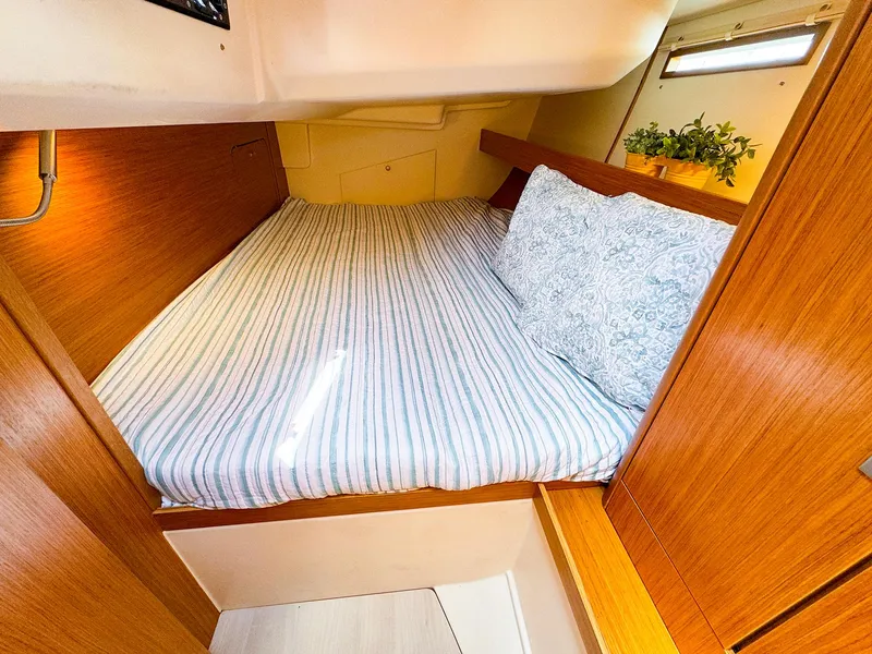 Slide: The Image of Cozy cabin bed in 2021 Dehler 42c sailboat with striped bedding and decorative pillows. - 39