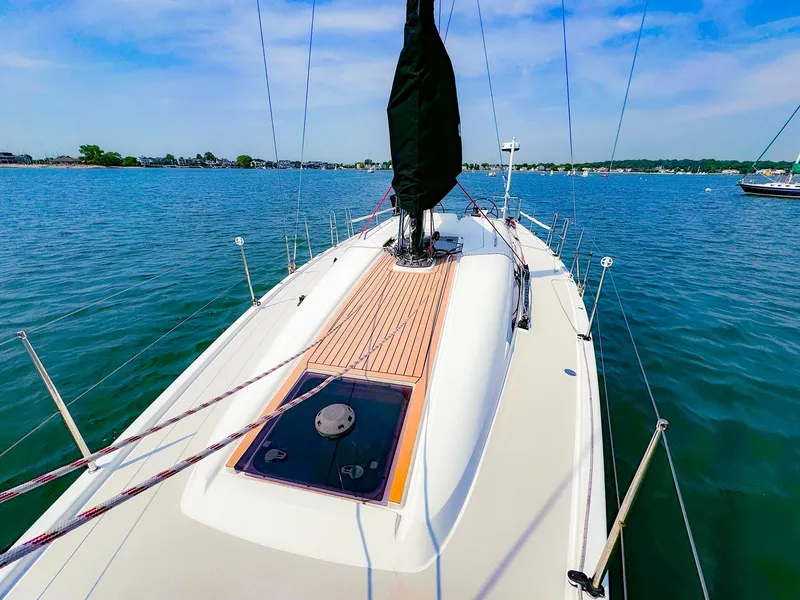 Slide: The Image of 2021 Dehler 42c sailboat on calm waters, featuring a sleek deck design. - 6