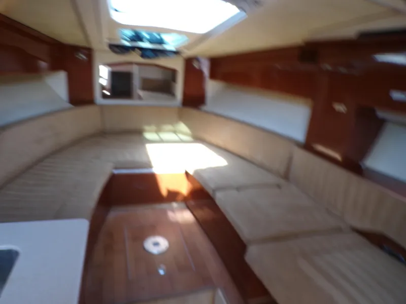Slide: The Image of Interior of a 2010 Sea Ray Sundancer yacht with beige seating and wooden flooring. - 12