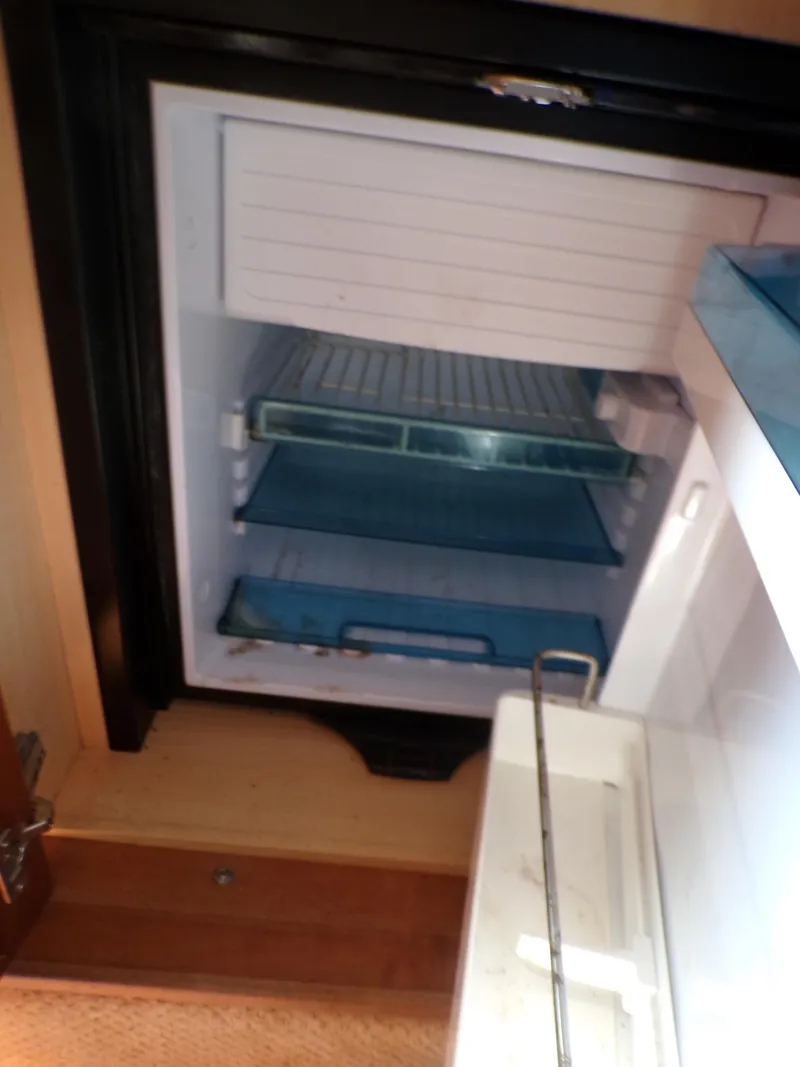 Slide: The Image of 2010 Sea Ray Sundancer refrigerator interior with shelves and compartments. - 14