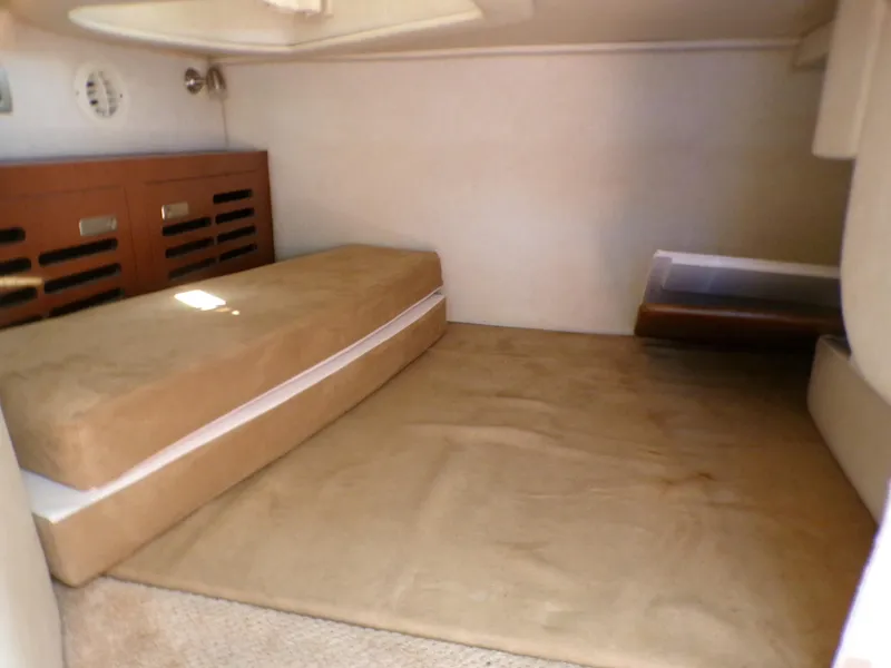 Slide: The Image of Interior cabin of 2010 Sea Ray Sundancer with beige cushions and wooden storage. - 17
