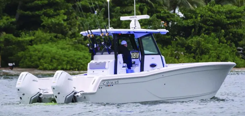 The Image of 2025 Caymas 30 CT boat cruising on water with fishing gear. - 1