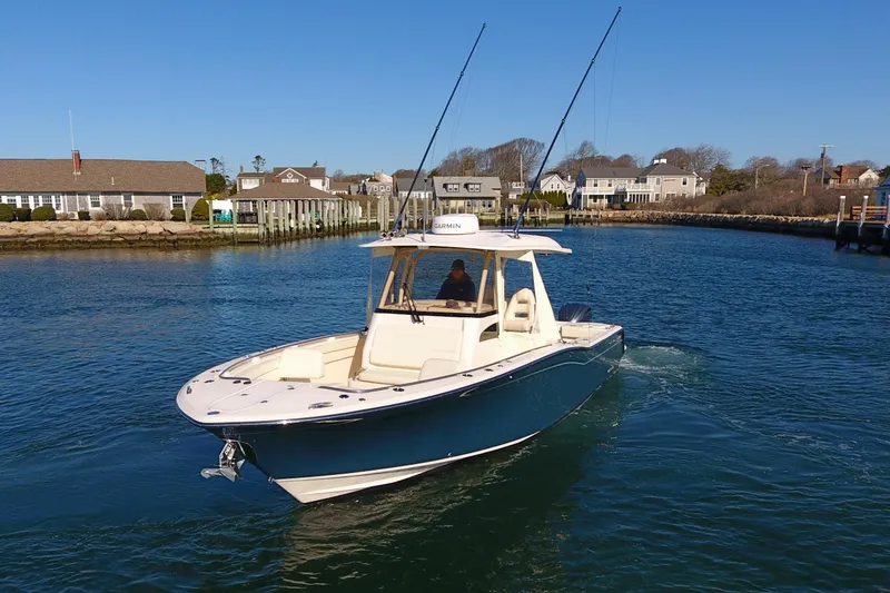 Slide: The Image of 2022 Grady-White Canyon 326 boat cruising in a scenic coastal area. - 10