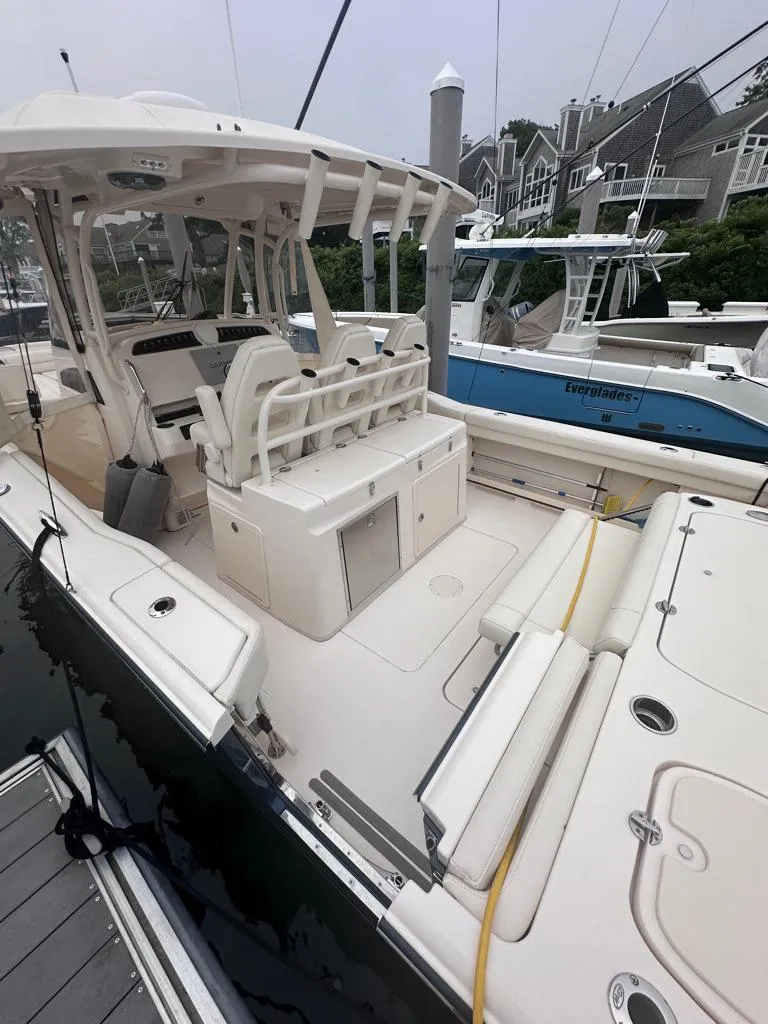 Slide: The Image of 2022 Grady-White Canyon 326 boat docked, showcasing spacious deck and seating area. - 14