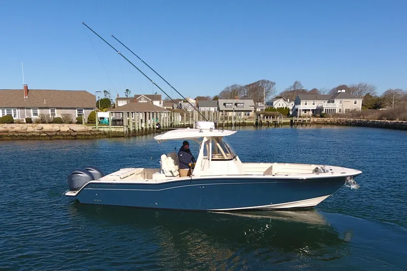 Slide: The Image of 2022 Grady-White Canyon 326 boat on calm water near coastal homes. - 1
