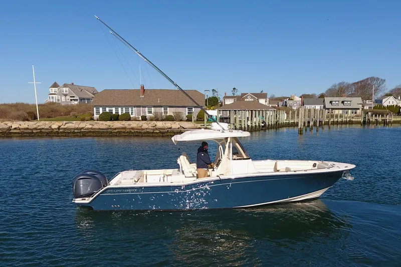 Slide: The Image of 2022 Grady-White Canyon 326 boat cruising in a scenic coastal area. - 2