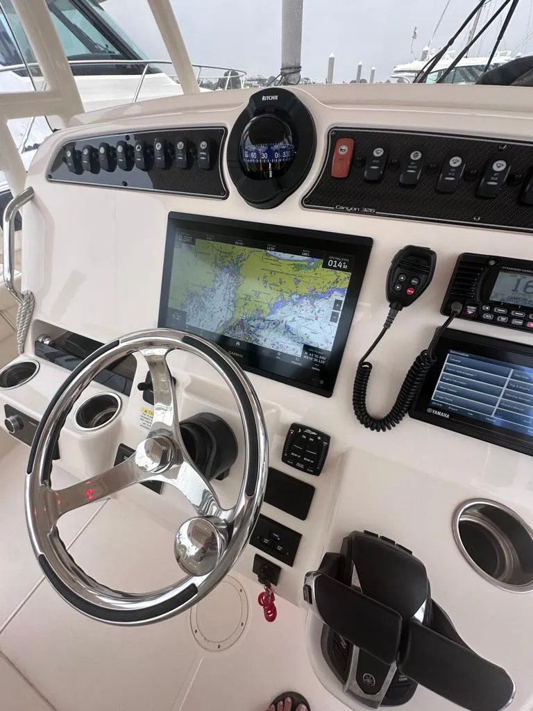 Slide: The Image of 2022 Grady-White Canyon 326 boat dashboard with navigation system and controls. - 26