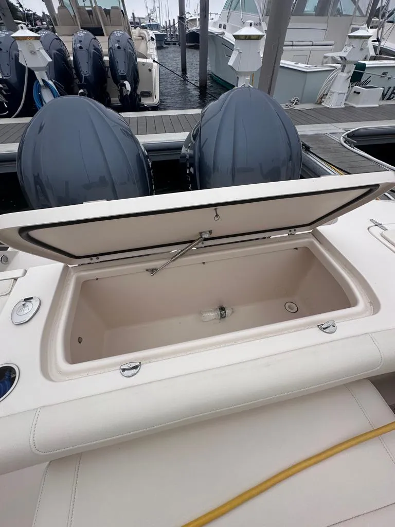 Slide: The Image of 2022 Grady-White Canyon 326 boat with open storage compartment and twin outboard engines. - 28