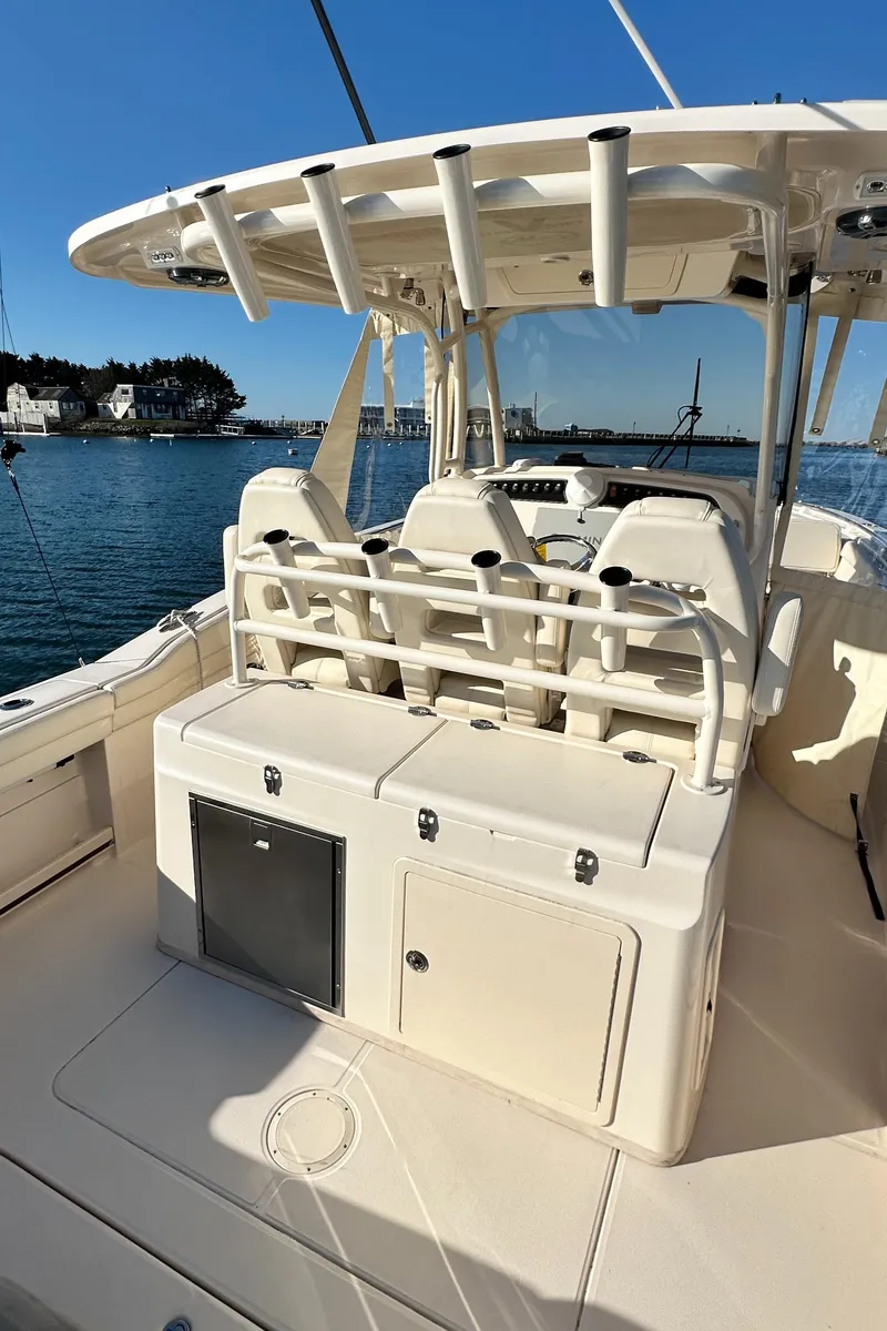 Slide: The Image of 2022 Grady-White Canyon 326 boat interior with seating and storage, docked by the water. - 32