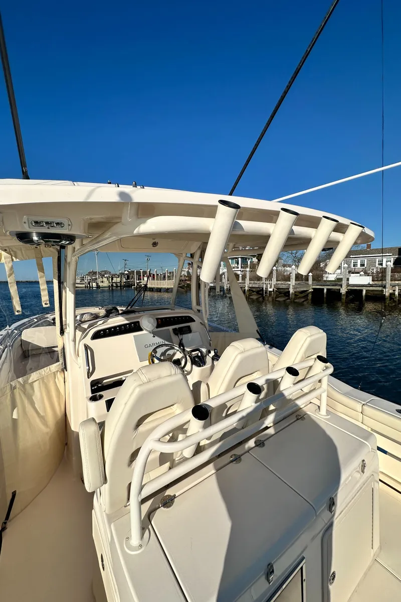 Slide: The Image of 2022 Grady-White Canyon 326 boat interior with rod holders, docked by the water. - 34
