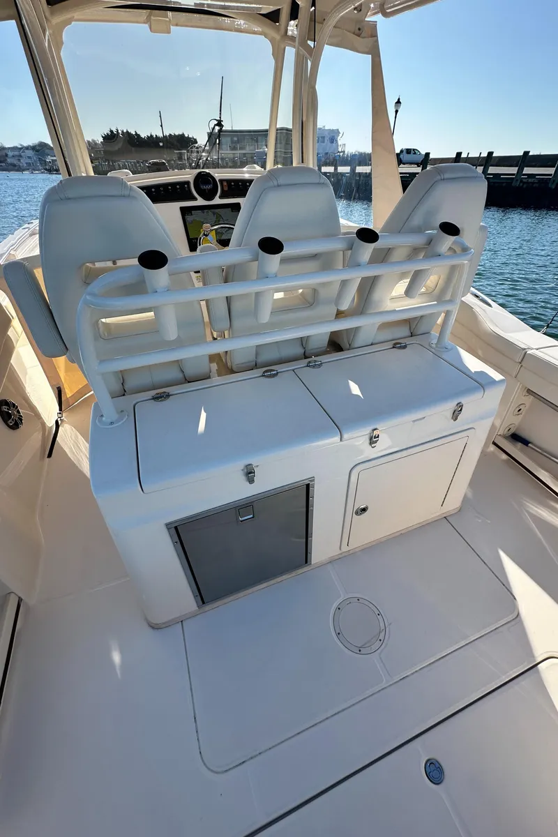 Slide: The Image of 2022 Grady-White Canyon 326 boat interior with seating and storage, docked by the water. - 38