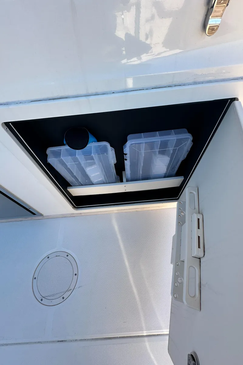 Slide: The Image of Storage compartment on a 2022 Grady-White Canyon 326 boat, featuring organized tackle boxes. - 39