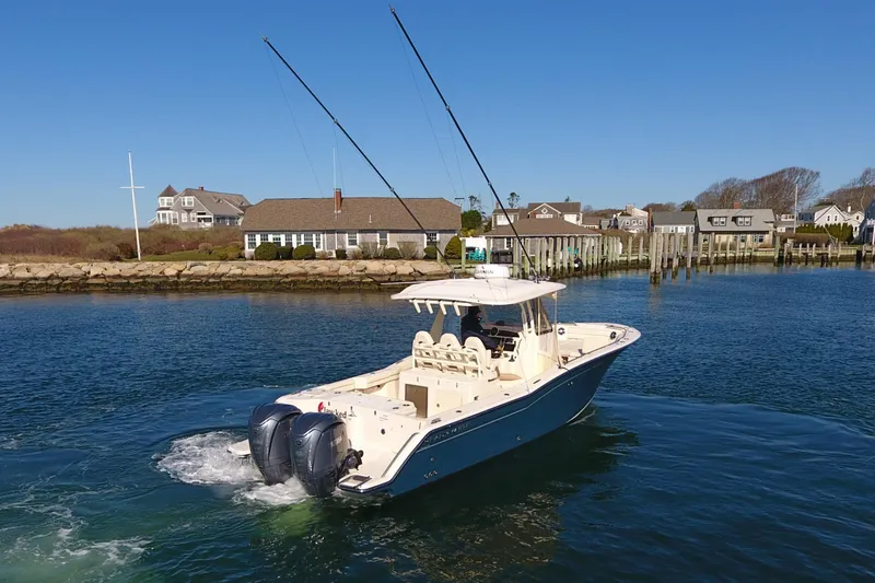 Slide: The Image of 2022 Grady-White Canyon 326 boat cruising near coastal homes. - 4