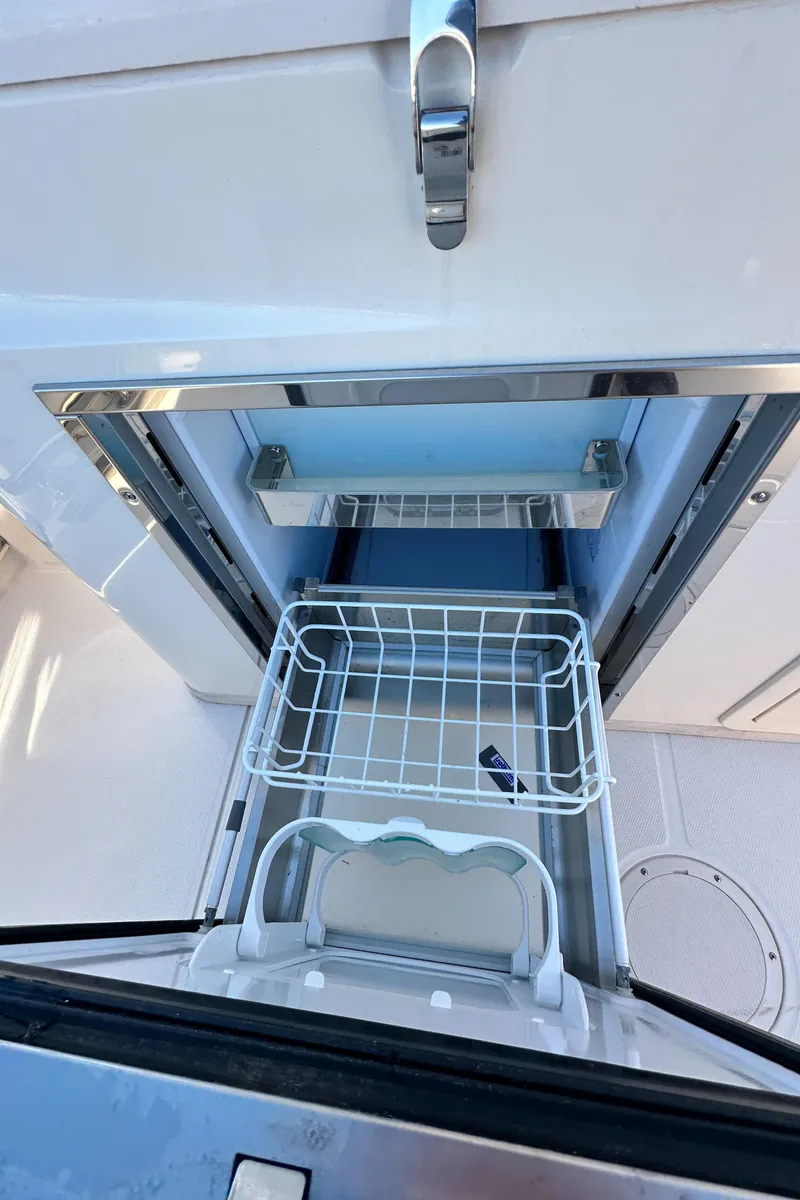 Slide: The Image of Grady-White Canyon 326 boat cooler compartment, 2022 model, with open lid and wire basket. - 40