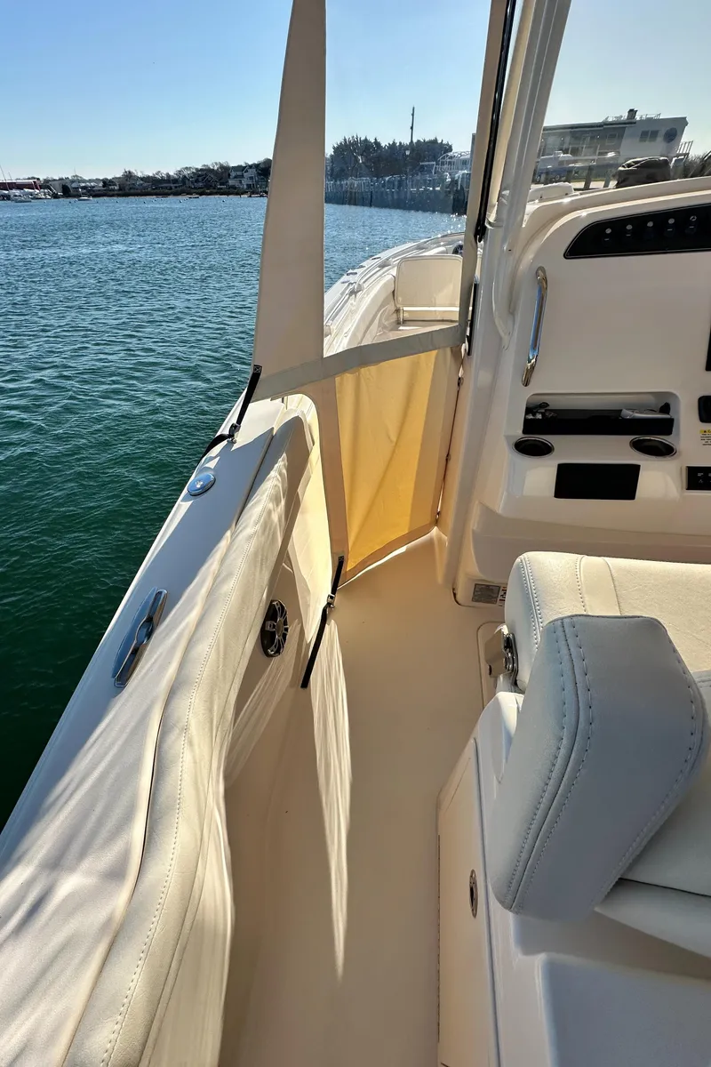 Slide: The Image of 2022 Grady-White Canyon 326 boat interior with seating and control panel, docked on calm water. - 41