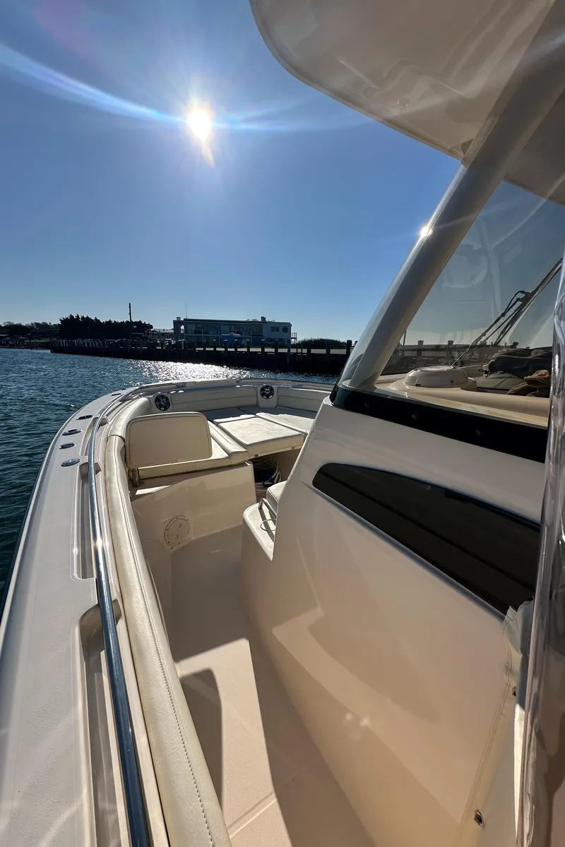 Slide: The Image of 2022 Grady-White Canyon 326 boat under sunny sky, docked near water. - 43