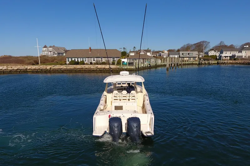 Slide: The Image of 2022 Grady-White Canyon 326 boat cruising in a scenic coastal area. - 5