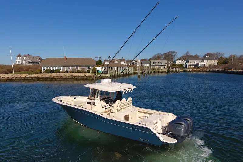 Slide: The Image of 2022 Grady-White Canyon 326 boat cruising in a scenic coastal area. - 6
