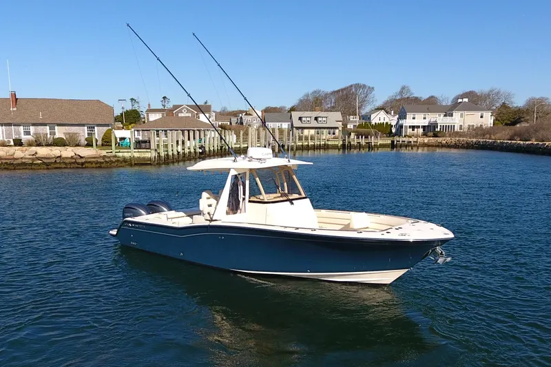 The Image of 2022 Grady-White Canyon 326 boat on calm water near coastal homes. - 0