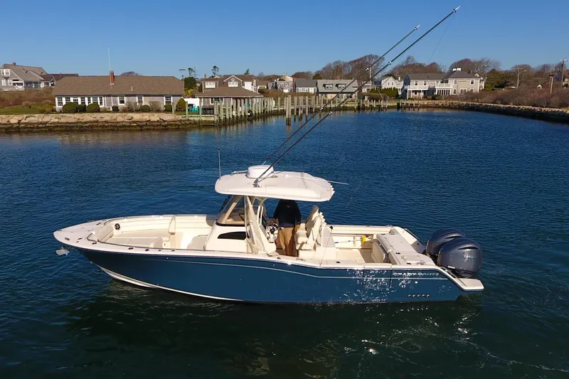 Slide: The Image of 2022 Grady-White Canyon 326 boat on calm water near coastal homes. - 8