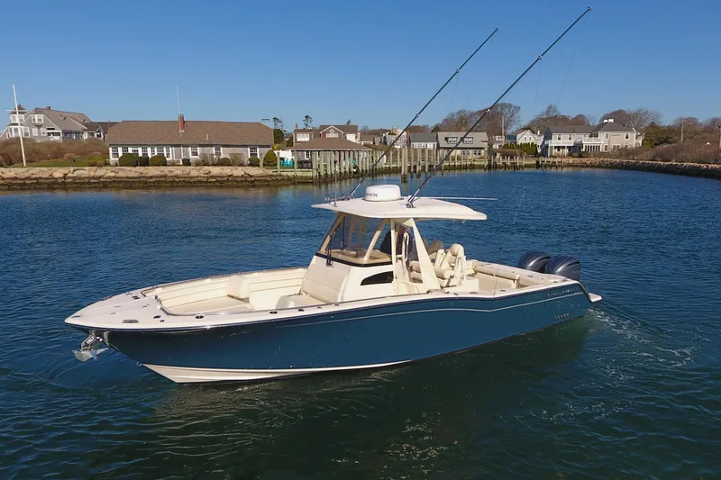 Slide: The Image of 2022 Grady-White Canyon 326 boat on calm water near coastal homes. - 9