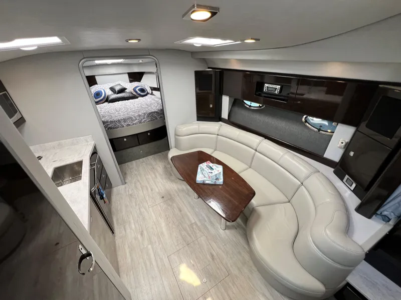 Slide: The Image of 2017 Formula 37 Performance Cruiser interior with modern kitchen, curved sofa, and cozy bedroom. - 21