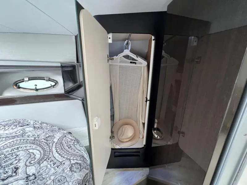 Slide: The Image of 2017 Formula 37 Performance Cruiser cabin closet with hanging clothes and hat. - 26