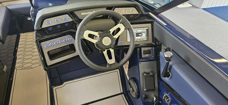 Slide: The Image of 2025 MasterCraft NXT22 boat dashboard with steering wheel and control panel. - 10